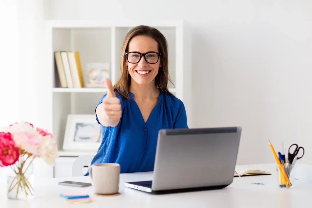 Bewertungsmanagement Symbolbild Frau vor Laptop hält Daumen hoch